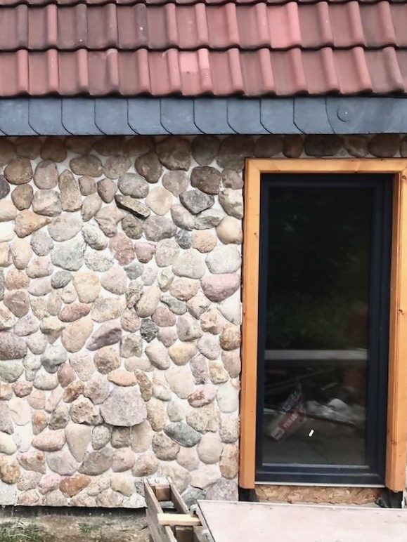 Fassade. Enden aus Stein. Stein lässt sich gut mit Holz und Keramikfliesen kombinieren.