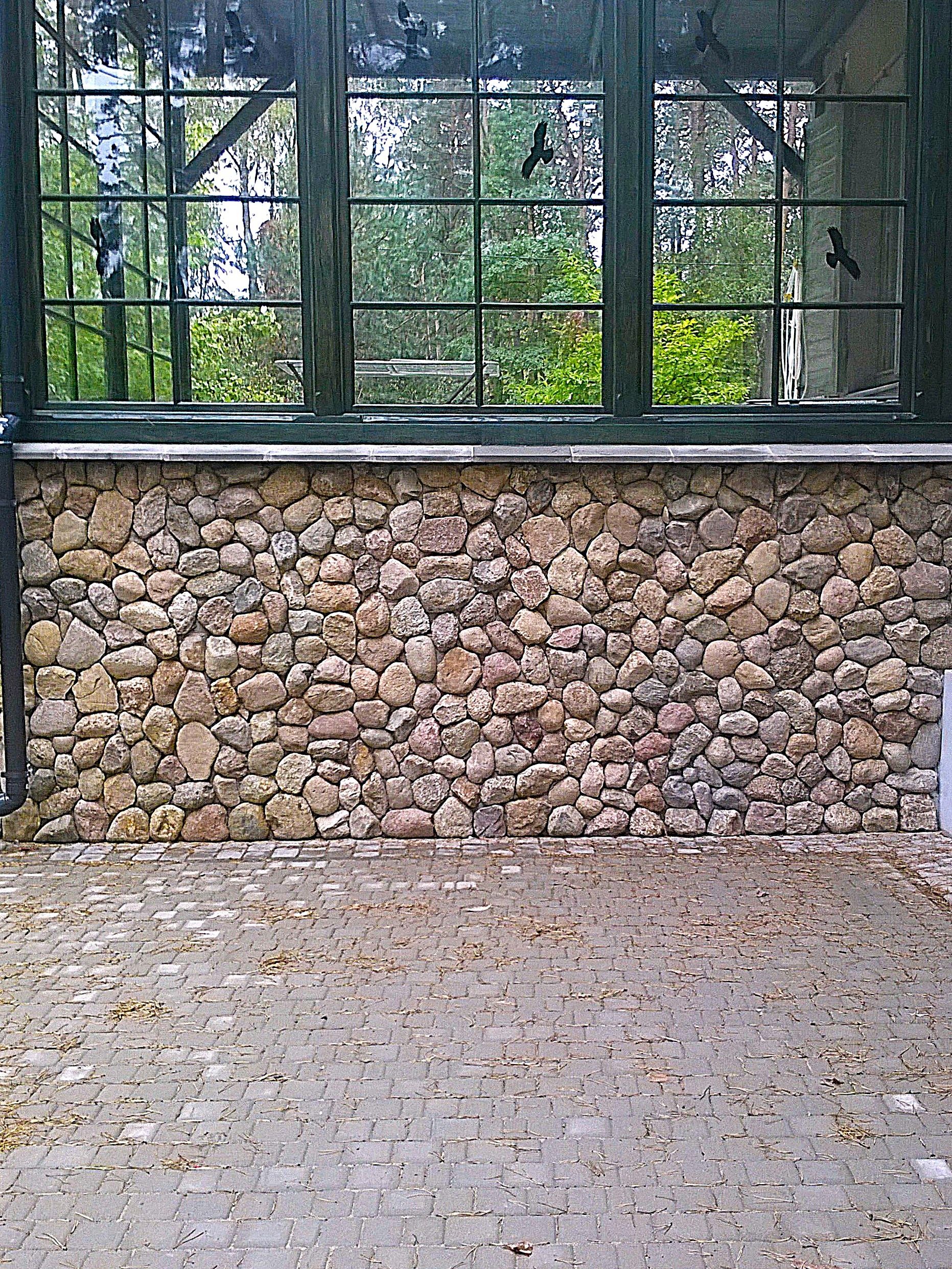 Veranda mit geschnittenen Steinabschlüssen. Ländlich, im Landhausstil.